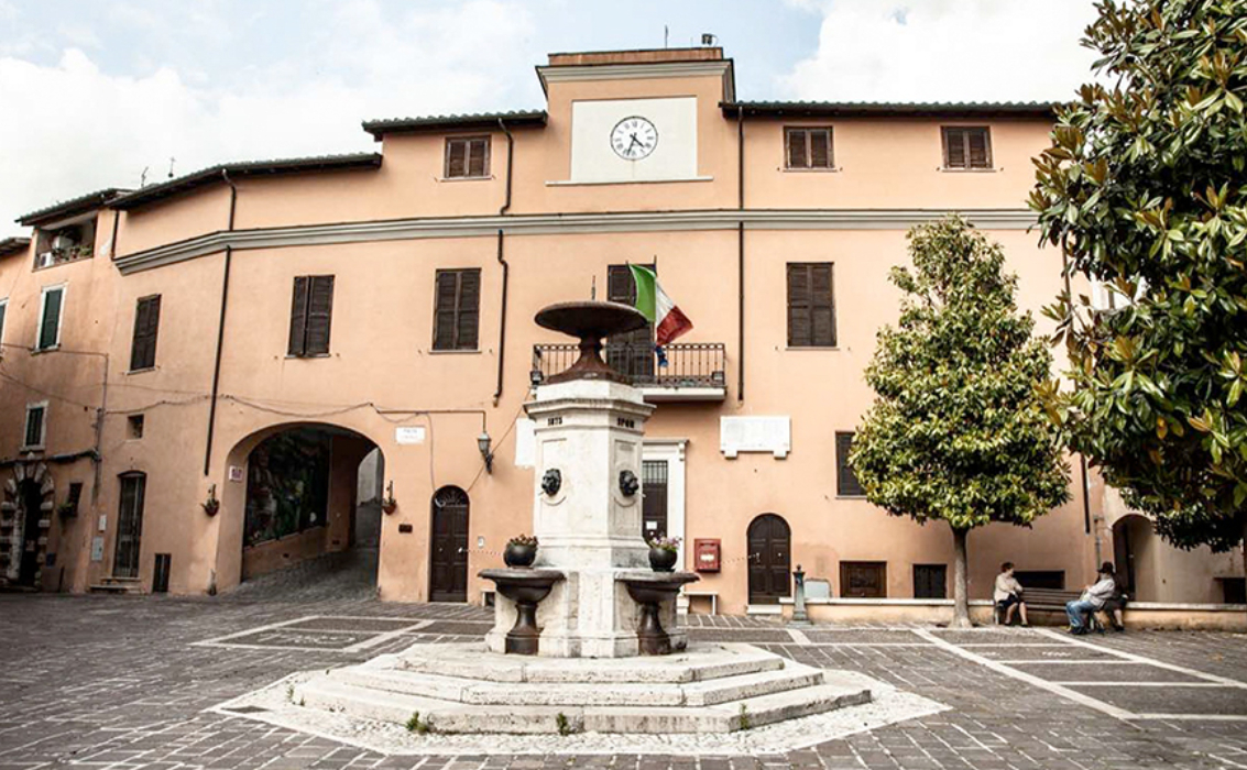 Piazza principale di Montopoli di Sabina con fontana centrale e palazzo del comune con orologio