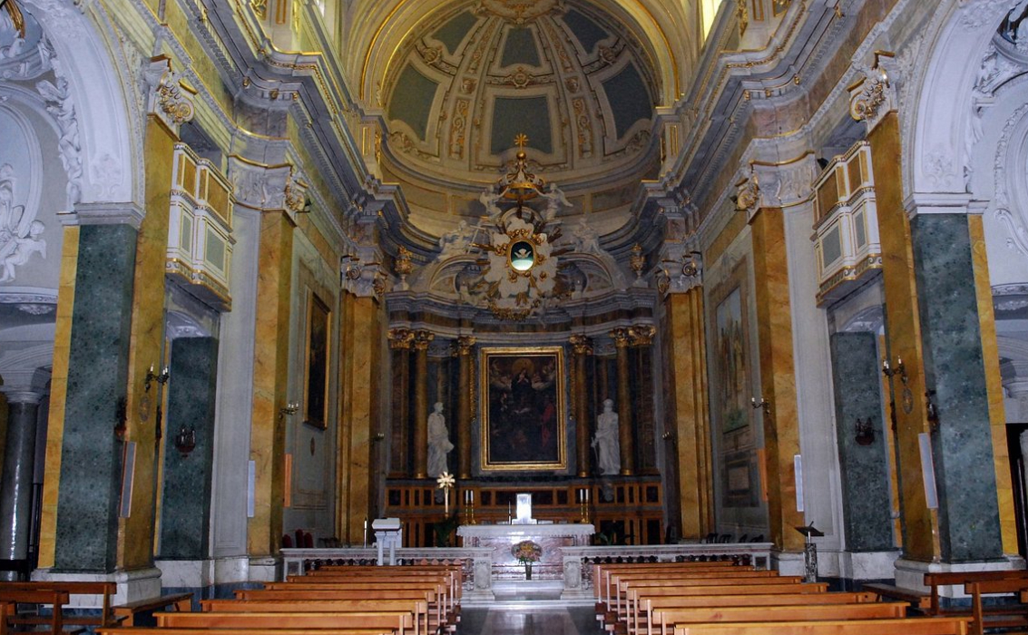 Interno riccamente decorato di una chiesa a Poggio Mirteto, con altare maggiore, colonne in marmo e affreschi sulla cupola.